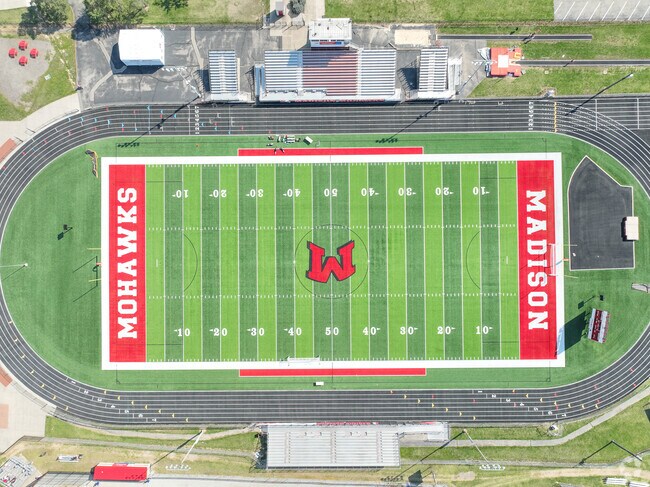 There is a football field that is located near the back of the school building.