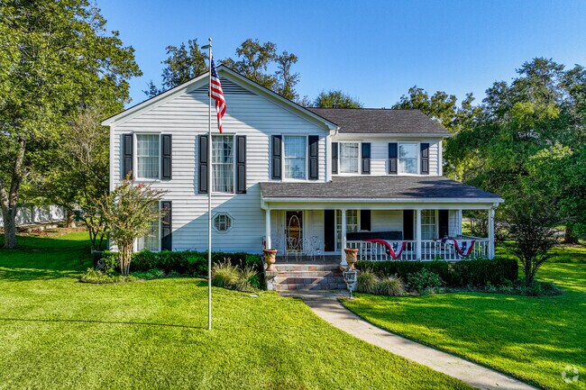 Classic colonial with colorful shutters and a front porch.