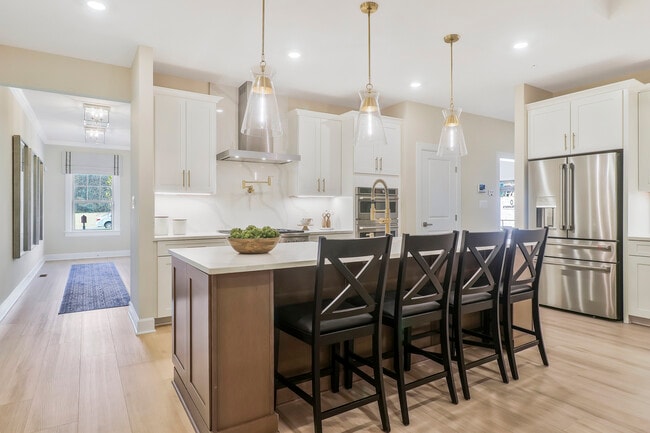 The chef in the family will love NVHomes' Signature Kitchen with included pendant lighting, farmhouse sink, ceramic tile backsplash, quartz countertops, and much more!