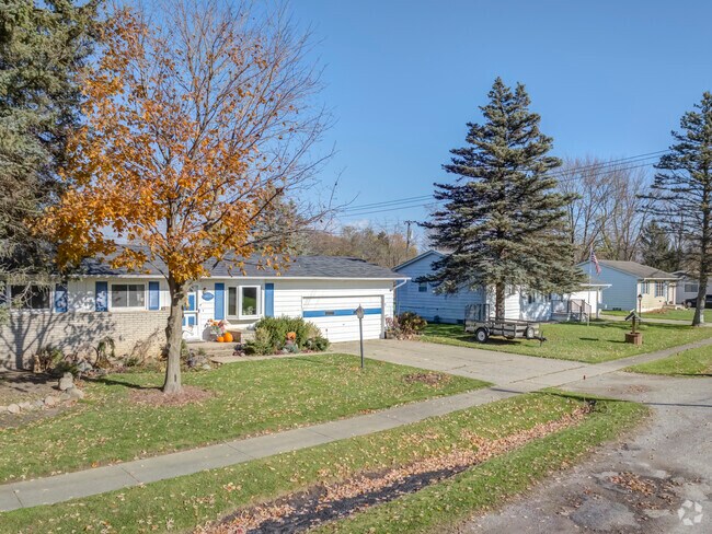 Ranch-style homes with attached garages sit under large trees on residential streets in Memphis.
