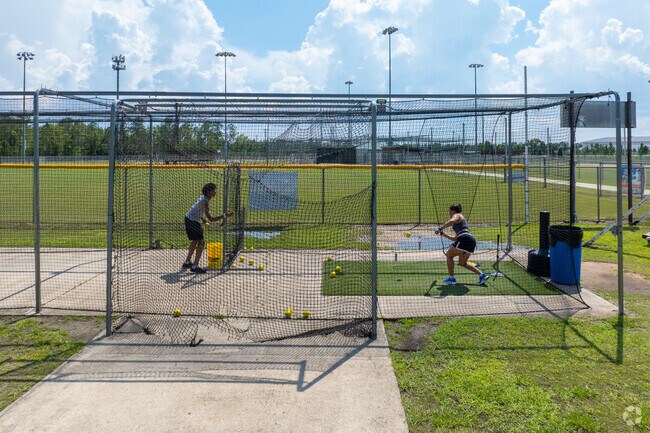 A woman practices her batting at the Oakleaf Community Park.