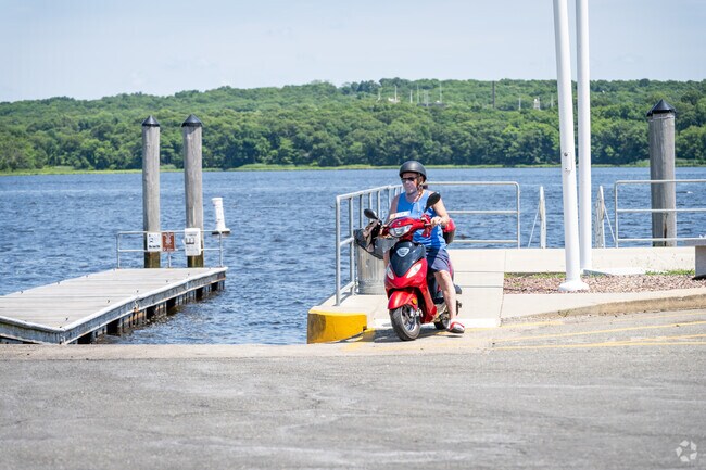 Ride your scooter through Village Waterfront Park in Pottersville, MA, admiring the waterfront.