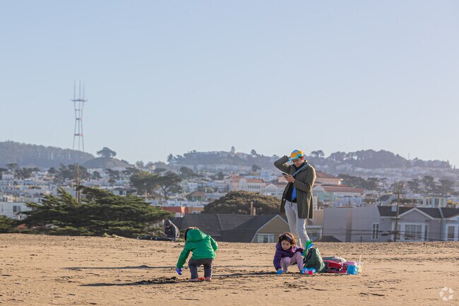 Family fun unfolds on Ocean Beach, with Sutro Tower in the backdrop.