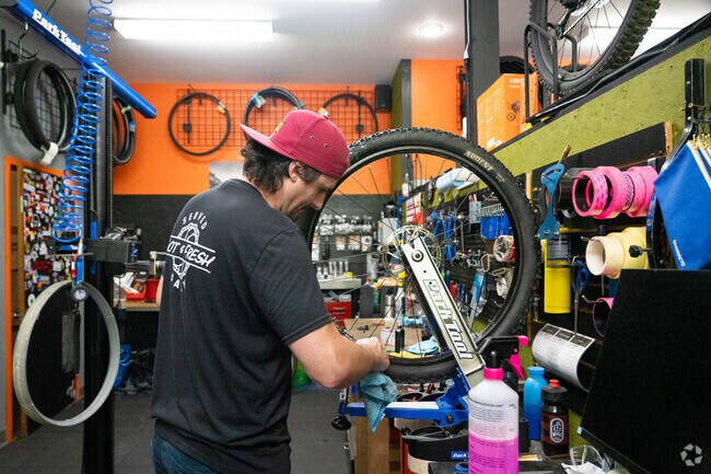 A repairman polishes a bicycle wheel at The Wheel House, a shop in Maple Avenue District.