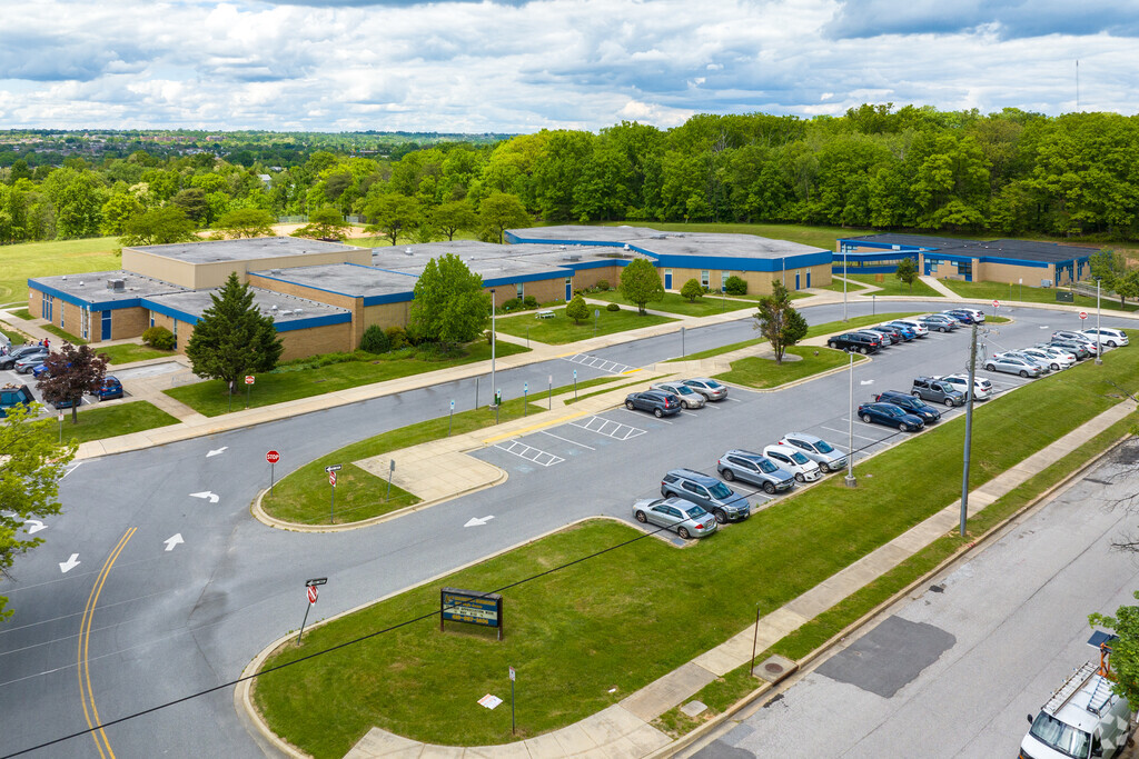Halethorpe Elementary School in Baltimore has a parking lot and grass islands in front.