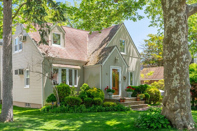 Charming cape cod homes can be seen shaded by mature trees and lush gardens.