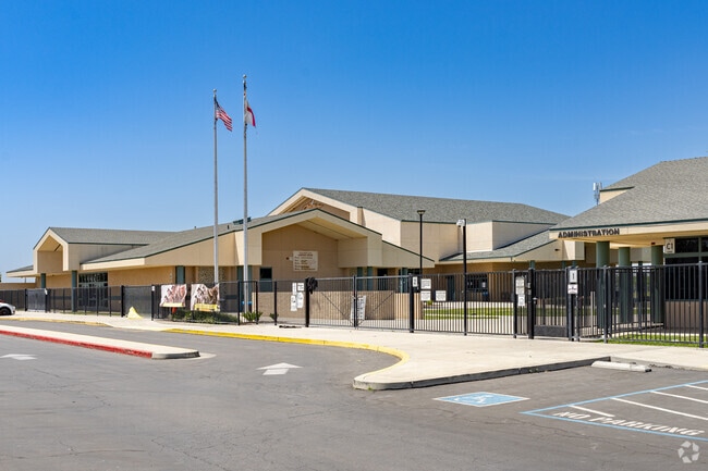 An American and California state flag wave at the entrance to Pixley Middle School.