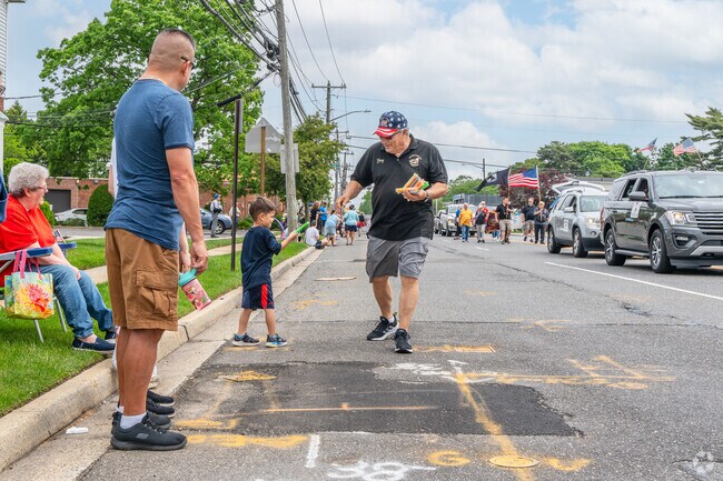 A boy watching the parade receives an ice pop from a parade participant.