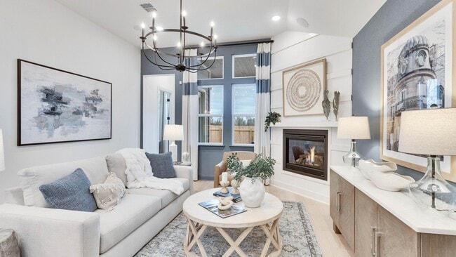Revel in this Spring Creek living room's chic chandelier, inviting fireplace, and exquisite decor.