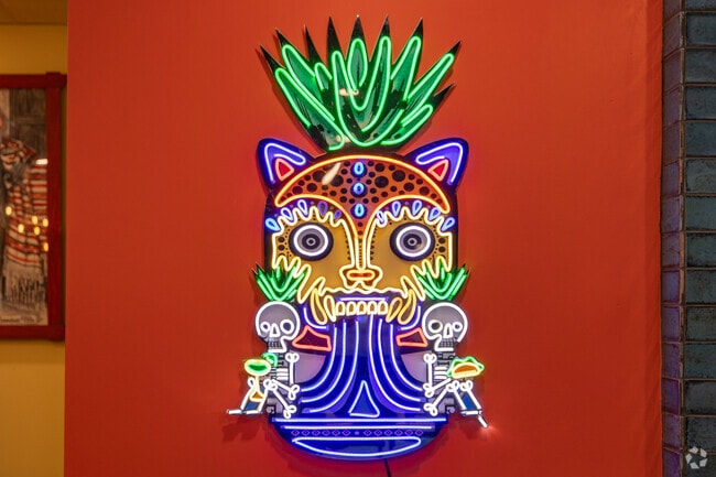 Neon art adorns the walls of Los Tres Caminos in Cambridge Village.