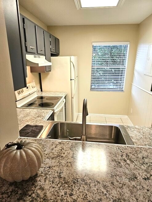 Deep stainless sink with a dual faucet sprayer and a detachable head.