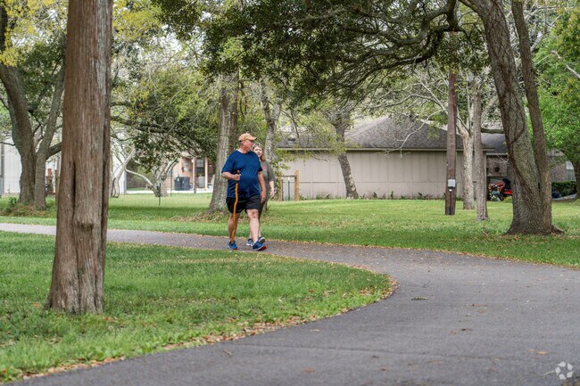 A couple takes a stroll along a walking trail at Tambrella Park in Santa Fe.