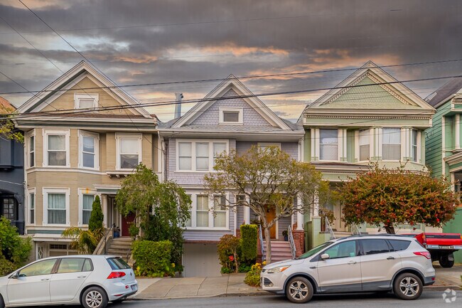 The sun puts on a show in the clouds above a row of Inner Richmond victorian-style homes.