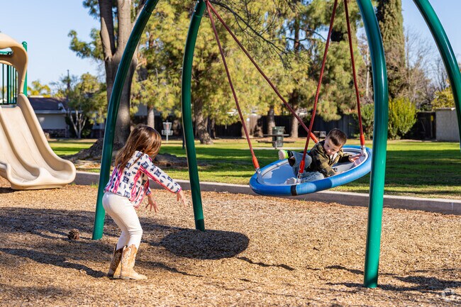 Fruitvale siblings thouroughly enjoy the swing at Olive Park East.