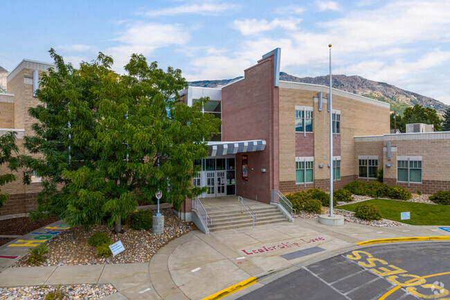 North Ogden has steps leading to a glass entrance surrounded by a building made of bricks.