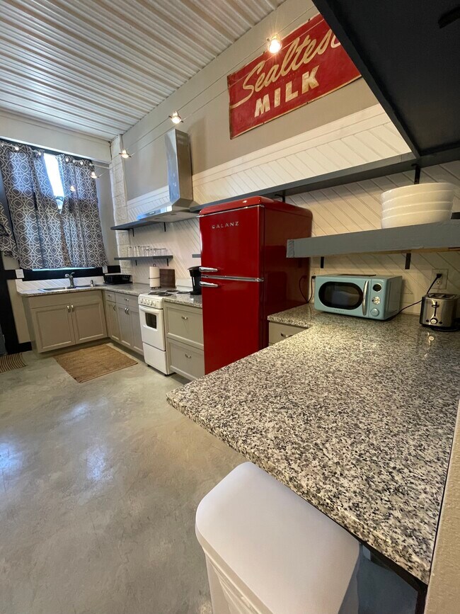 Kitchen sink and window, chrome vent a hood.