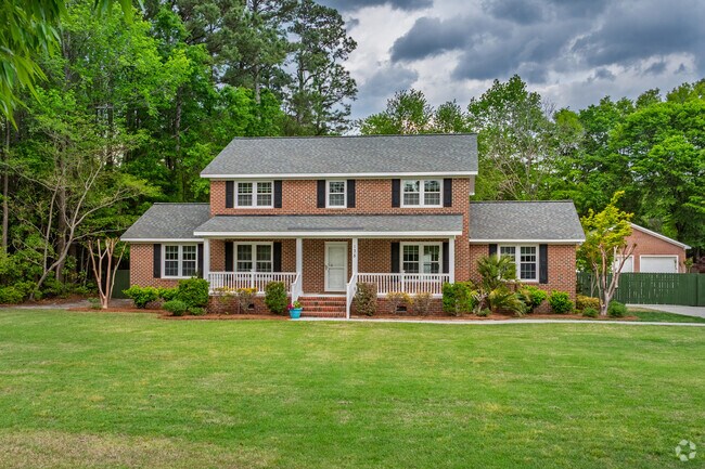 A brick traditional home in Rogersville-Bradley Creek showcases a well-manicured lawn.