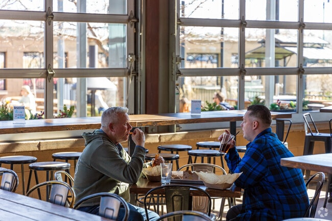 Wooden picnic tables and greenery create a cozy feel at the Green Valley Ranch Beer Garden.