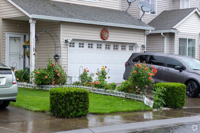 Flowering gardens brighten homes in Fisher’s Village‑Orchards.