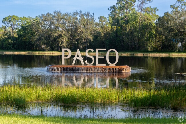 A lakeside sign with waterfalls marks the entrance to Paseo in Fort Myers.