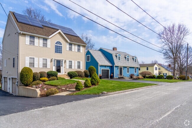 A row of colorful single-family homes in Hamilton lines a quiet street.