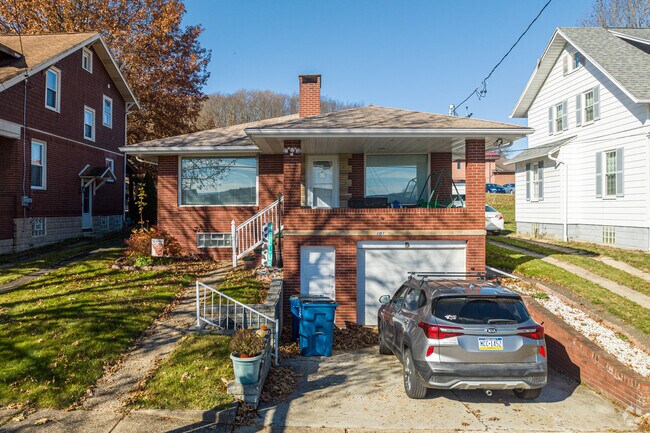A bungalow is flanked by two craftsman-style houses on this street.