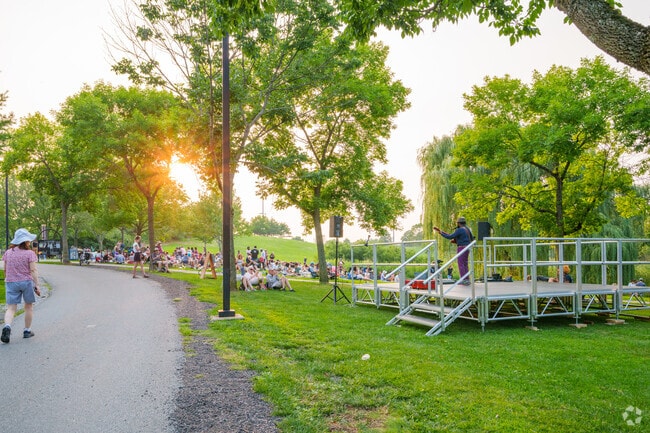 People walk up beside the stage, joyful, at the Danehy Park Concert Series.