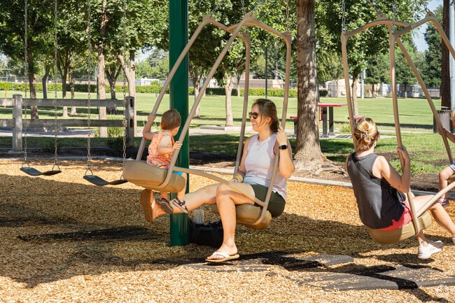 Two mothers from North Visalia enjoy swinging with their young daughters.