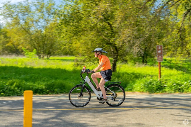 A man enjoys a scenic trip through River Bend Park in Cordova Meadows on an electric bike.