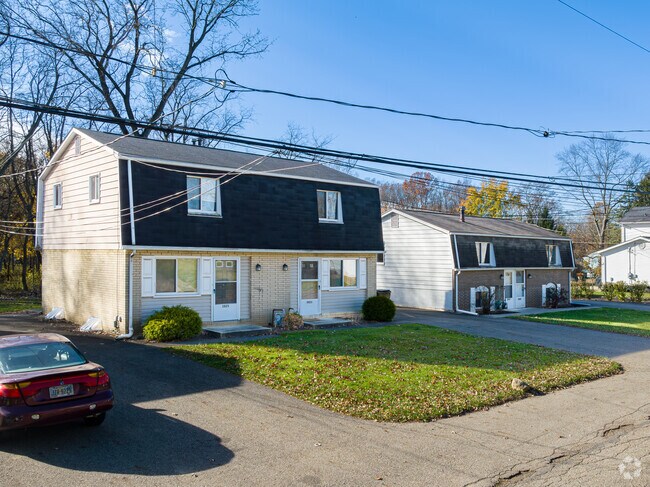 A row of mid to late 20th century Mansard style homes with their distinct roofs in New England.