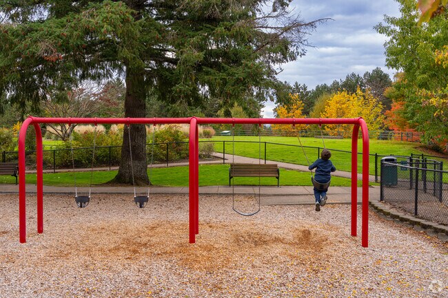 Families enjoy the playground and swing set at Elizabeth Price Park in East Bull Mountain.