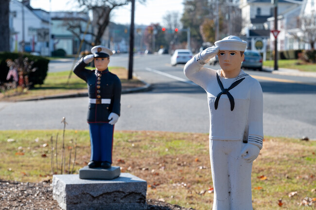 A Marine and Sailor salute the memorial for Veterans in West Brookfield.