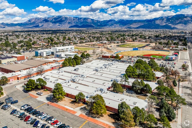 An aerial view of Sandia High School with the Sandia Mountains in the distance.