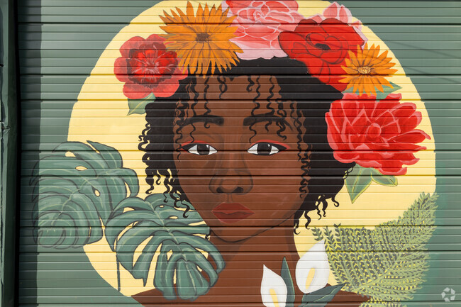Woman with flowers in her hair mural on Coffeeweed Cottage in the West End, Lafayette.