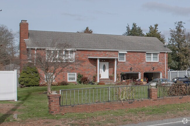 A sturdy brick faced raised ranch is stalwart on its verdant lawn in the Acushnet neighborhood.
