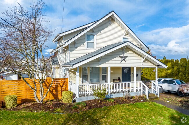 Precious two-story home with a small detached shed in a fenced-in yard.