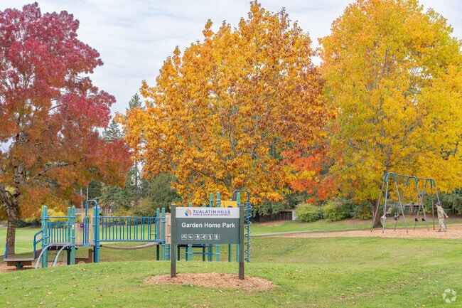 Play on the slides, swings, and the open green space at Garden Home Park.
