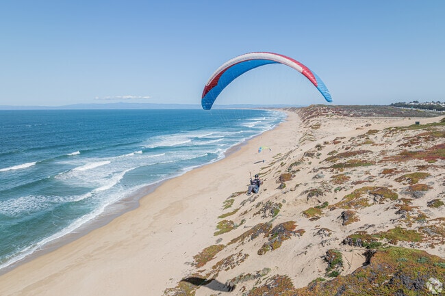 Paragliders soar above the scenic shores just minutes from Casanova Oak Knoll’s sunny streets.