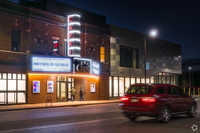 The Capri Theater on West Broadway shines brightly as residents pass by.