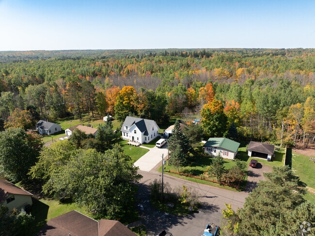 Many homes are set again a vast wooded backdrop.