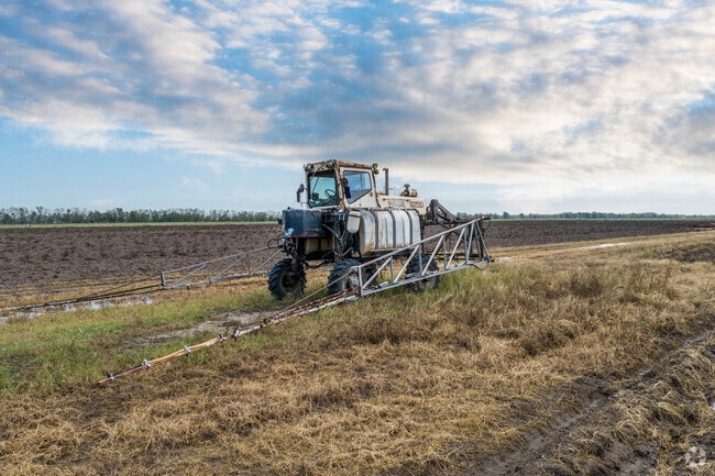 An older tractor sits on a prairie located in rural Damon, Texas.