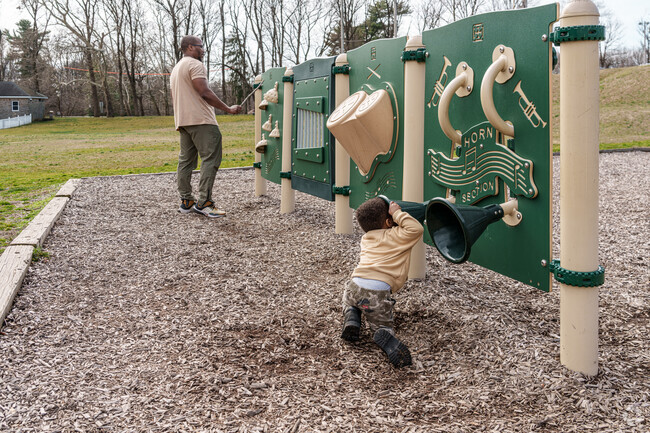 A father and son make music on the outdoor instruments at Glenolden Park.