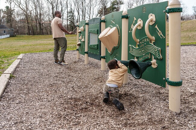 A father and son make music on the outdoor instruments at Glenolden Park.
