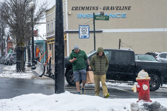 Two men walk along the Depot Village in Palmer.