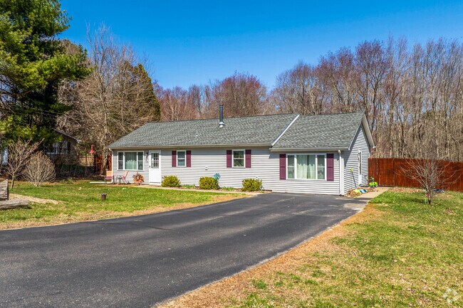 A ranch style home in Lisbon has a red fence that matches the red shutters on the house.