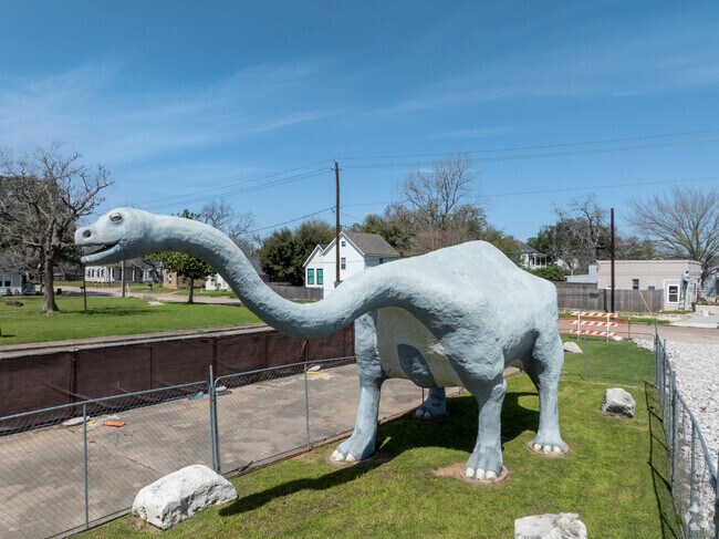 Pose with the climbable sculpture at Dinosaur Park, a must-see interactive piece in Wharton.