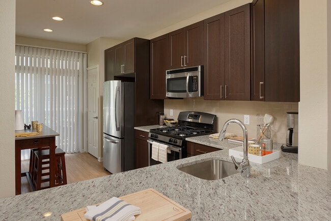 Espresso Finish Package kitchen with granite countertops, stainless steel appliances and hard surface flooring