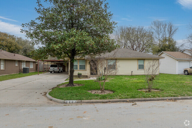 A single story home sits underneath the shade of an oak tree in Galena Park.