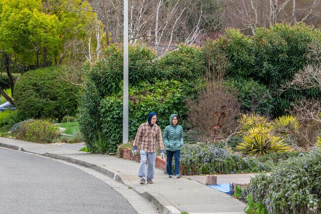 A couple enjoys a peaceful walk through the lush, tree-lined streets of the Campolindo neighborhood.