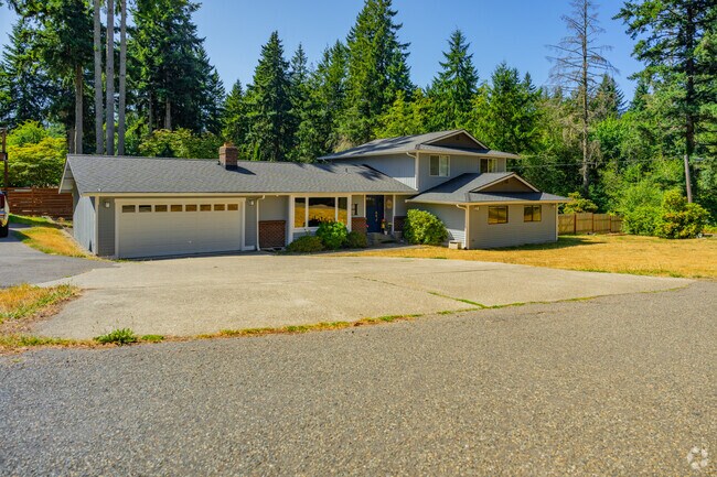 The newer homes in Artondale sit in lots full of massive trees.